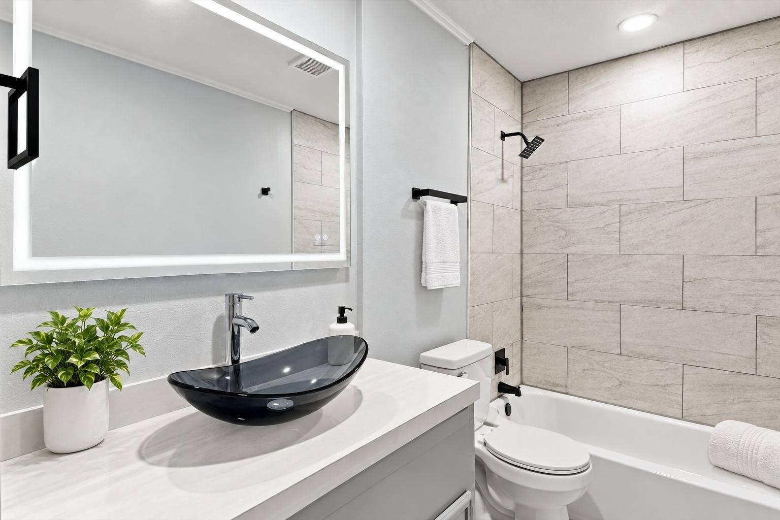 Refreshed bathroom with vessel sink and tiled tub surround at 2381 Deer Oak Place